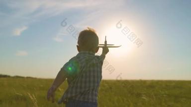快乐的孩子，男孩，在阳光下奔跑，在夏天的田野里玩着玩具飞机。那孩子驾驶着一架玩具飞机。儿子梦想着飞行。快乐的家庭在<strong>公园</strong>里<strong>玩耍</strong>。在户外<strong>玩耍</strong>的无忧无虑的孩子